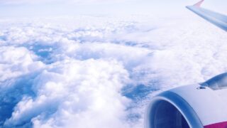 飛行機の窓から見た雲の上の空